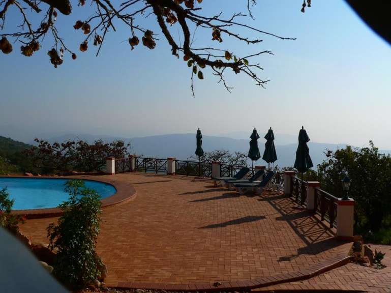 Ein Pool mit Liegestühlen und Sonnenschirmen umgeben