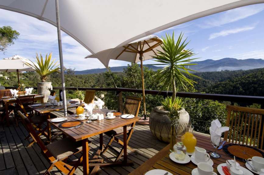 Tische und Stühle auf einem Deck mit Blick auf die Berge