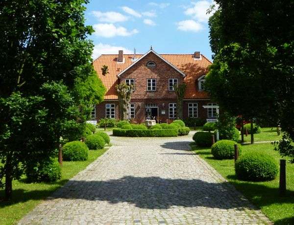 Ein Steinweg führt zu einem großen Backsteinhaus .