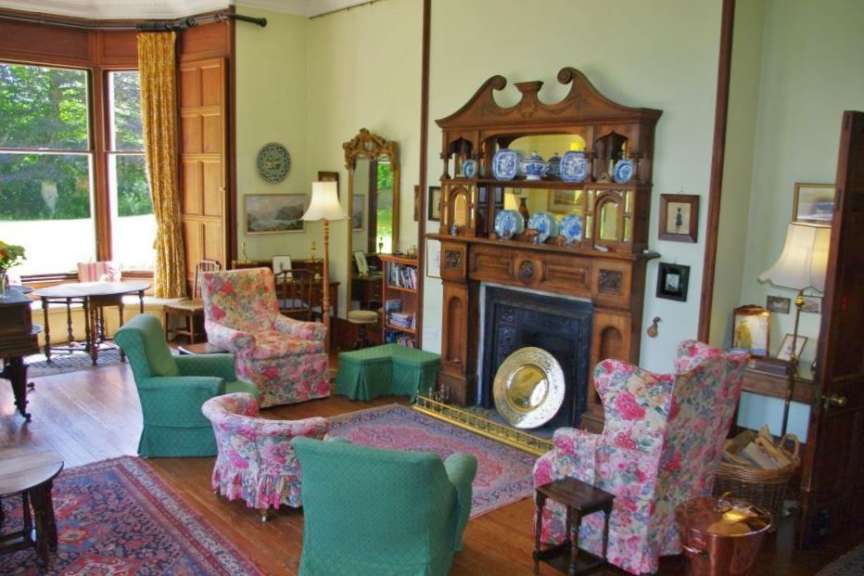 Ein Wohnzimmer mit vielen Stühlen und einem Kamin