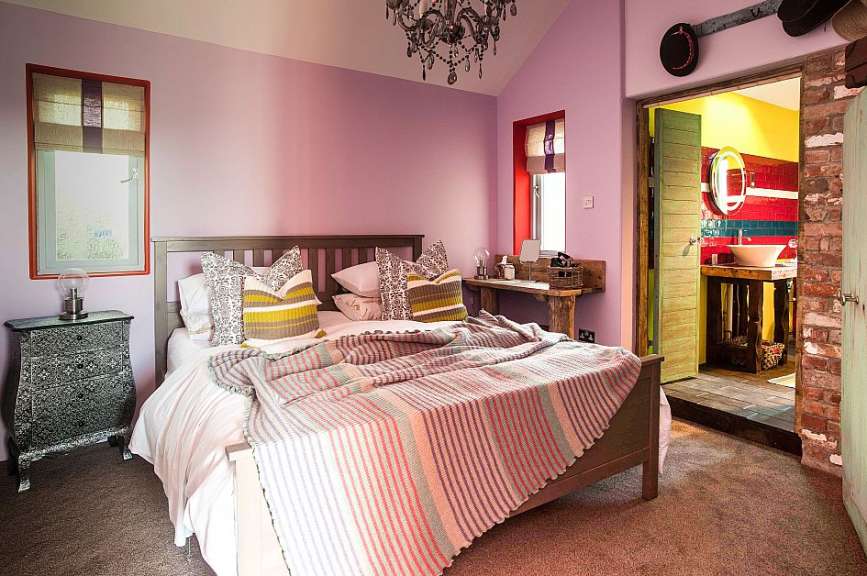 Ein Schlafzimmer mit lila Wänden und einem Bett