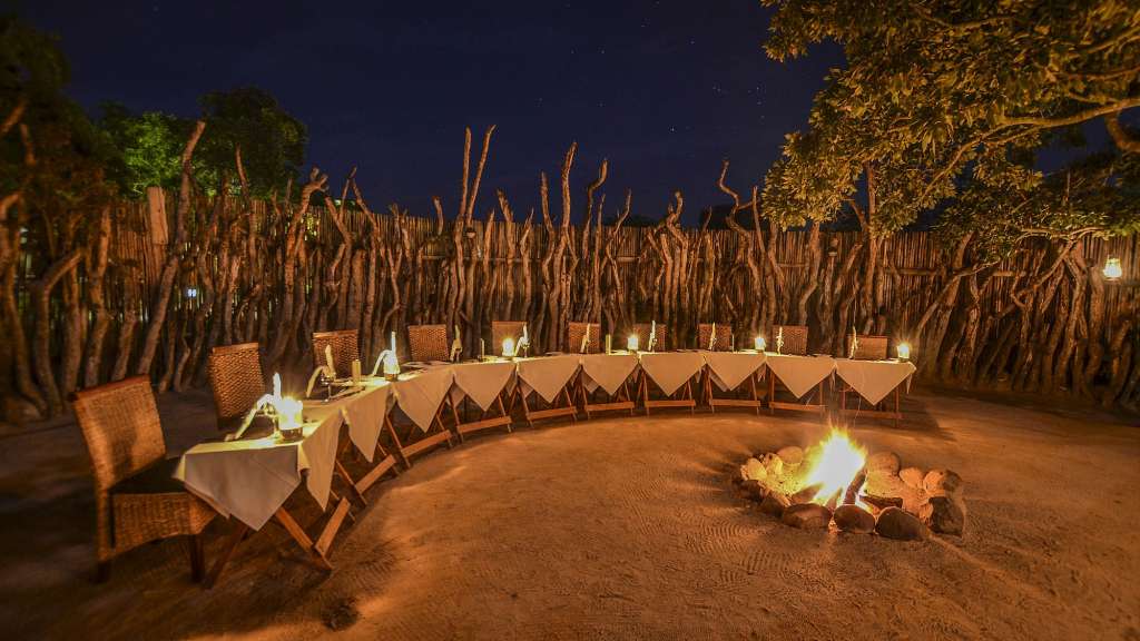 Ein Tisch und Stühle stehen rund um ein Feuer /media/cache/w1024-h576-c1024x576/11039551.jpg.webp