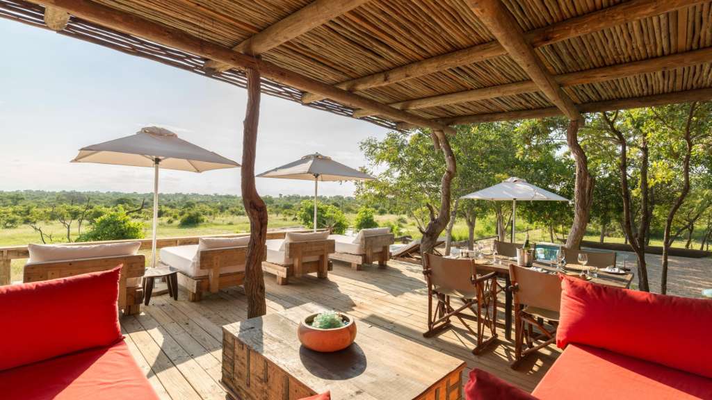 Ein Holzdeck mit roten Möbeln und Regenschirmen /media/cache/w1024-h576-c1024x576/11107073.jpg.webp