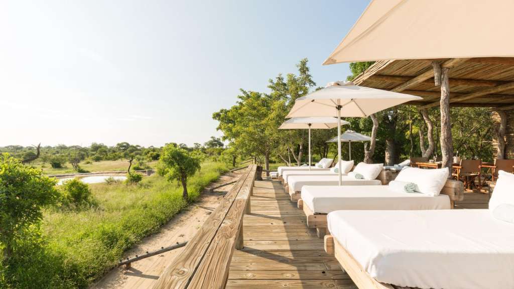 Eine Holzterrasse mit Liegen und Sonnenschirmen /media/cache/w1024-h576-c1024x576/11107074.jpg.webp