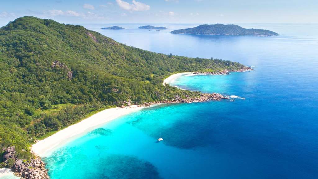 Ein Strand mit einem weißen Sandstrand und einem blauen Ozean
