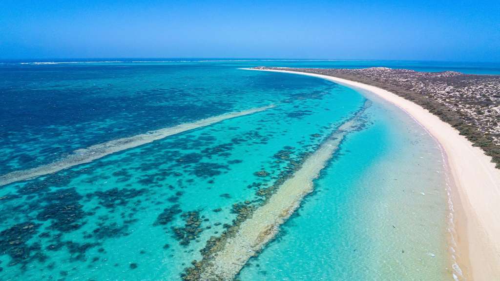 Ein weißer Strand inmitten eines türkisfarbenen Ozeans