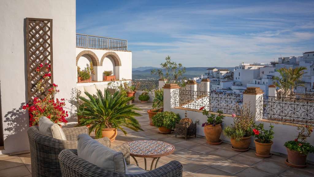 Fernblick nach Marismas: Haus des Kalifen Eine Terrasse mit Stühlen und einem Tisch mit Blumentöpfen /media/cache/w1024-h576-c1024x576/11113467.jpg.webp