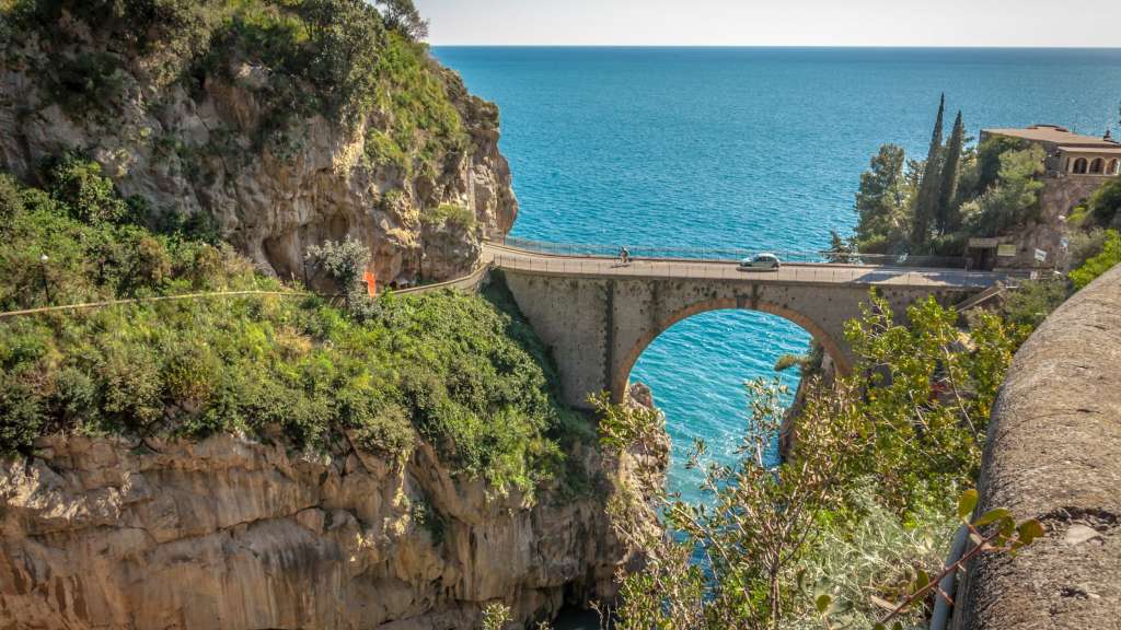 Ein Auto fährt auf einer Brücke über den Ozean