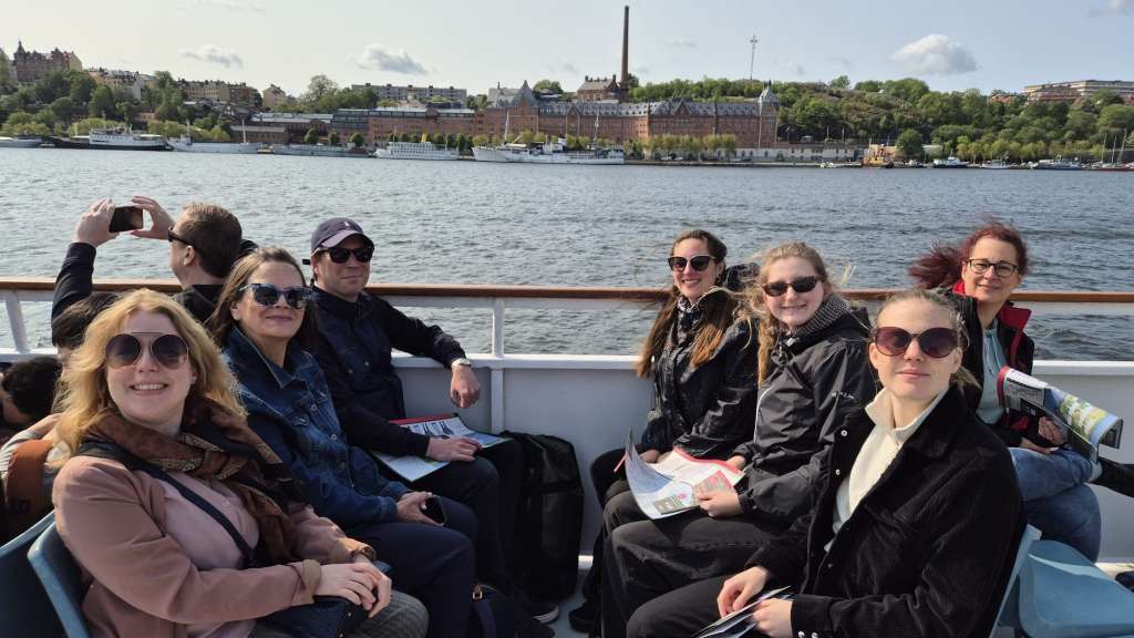 Eine Gruppe von Menschen sitzt auf einem Boot und schaut auf das Wasser