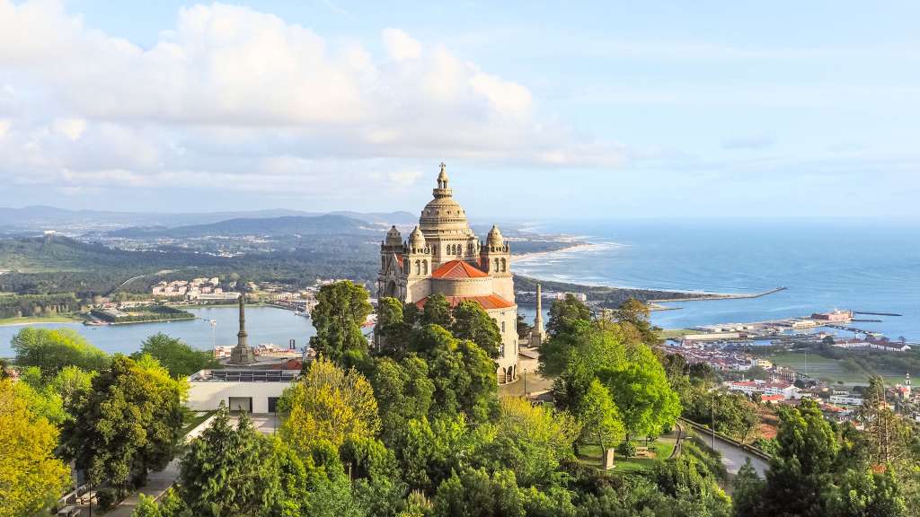 Eine malerische Aufnahme der Wallfahrtskirche von Sameiro, die auf einem Hügel mit Blick auf die Stadt und das Meer thront.