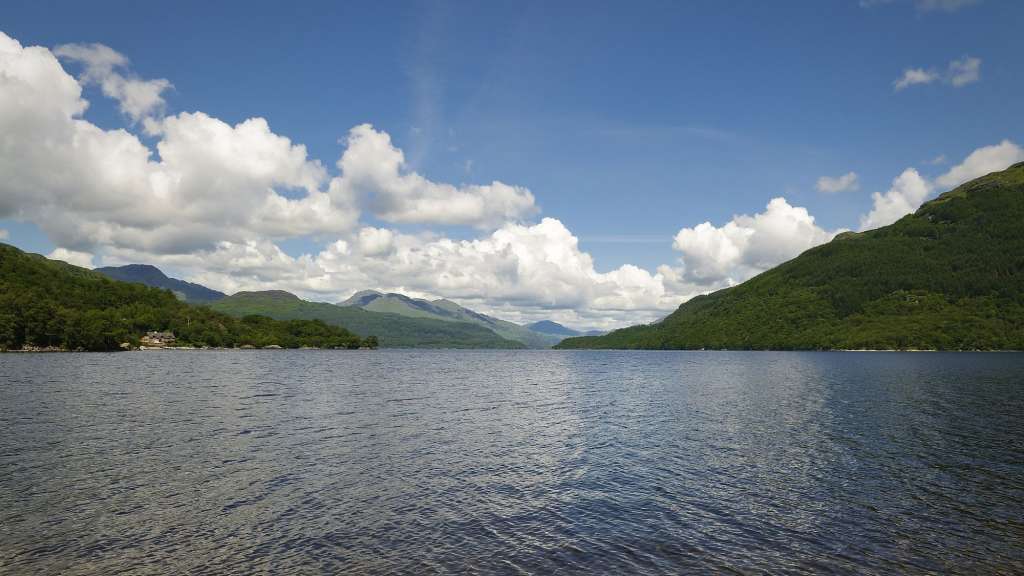 Ein See mit Bergen im Hintergrund an einem sonnigen Tag