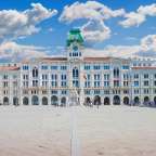 Ein großes weißes Gebäude mit einem grünen Uhrturm