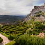 Ein labyrinthförmiger Garten mit einem Schloss im Hintergrund