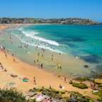 Ein Strand mit vielen Menschen und einem blauen Ozean