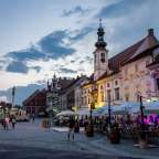 Eine Gruppe von Menschen geht an einem alten Gebäude vorbei