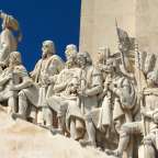 Eine Statue einer Gruppe von Männern steht auf einem Gebäude