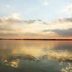 Ein See mit einem Sonnenuntergang im Hintergrund
