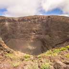 Ein großer Krater in einem Berg mit einem blauen Himmel im Hintergrund