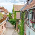 Eine schmale Straße zwischen zwei Gebäuden mit Fensterläden