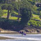 Ein Surfer trägt ein Surfbrett mit der Aufschrift ' hawaii ' darauf