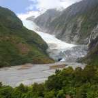 Ein Fluss fließt durch einen Berg mit einem Gletscher im Hintergrund