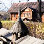 Ein hölzerner Zaun vor einem Holzhaus