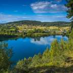 Ein blauer See umgeben von Bäumen und Häusern
