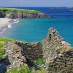 Ein Steingebäude steht auf einem Hügel mit Blick auf das Meer