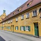 Eine Gruppe von Menschen geht an einem gelben Gebäude vorbei