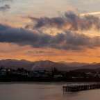 Ein Sonnenuntergang über einem See mit Bergen im Hintergrund