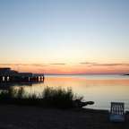 Ein Sonnenuntergang über einem See mit einem Gebäude im Hintergrund