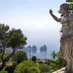 Eine Statue eines Mannes steht auf einem Hügel mit Blick auf das Meer