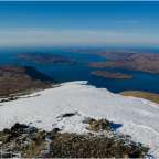 Ein schneebedeckter Berg mit einem großen See im Hintergrund