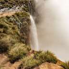 Ein Wasserfall stürzt von einer Klippe in den Nebel