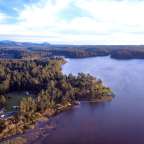 Ein großer See umgeben von Wäldern und Bergen