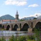 Eine Brücke über einen Fluss mit einer Kirche im Hintergrund