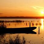 Eine Silhouette eines Bootes in einem See bei Sonnenuntergang