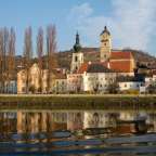 Eine Stadt mit einer Kirche und einem Fluss im Vordergrund