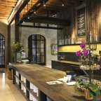 Eine Küche mit einem großen Holztisch und einer schwarzen Tafel mit einem Menü darauf