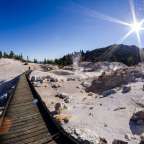 Eine Person geht auf einem Holzsteg in einem trockenen Gebiet