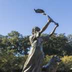 Eine Statue einer Frau mit einem Löwen dahinter