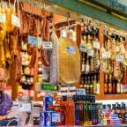 Eine Frau steht an einem Marktstand und zählt Flaschen