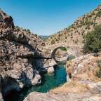 Eine Brücke über einen Fluss zwischen zwei Felsen