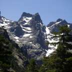 Ein schneebedeckter Berg mit Bäumen im Vordergrund
