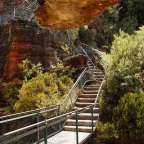 Eine Treppe führt hinunter zu einem roten Felsen