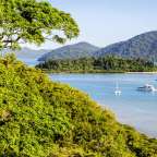 Ein Boot fährt durch einen See mit Bergen im Hintergrund