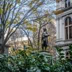 Eine Statue von benjamin franklin steht vor einem Gebäude