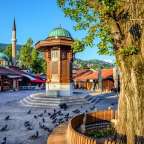 Ein Brunnen mit einer grünen Kuppel steht inmitten einer Stadtstraße