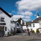 Eine Gruppe von Menschen sitzt vor einem Gebäude mit einem Schild, das sagt " the honeypot "