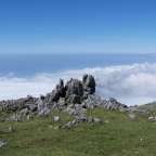 Ein Berggipfel mit einem großen Felsen darauf